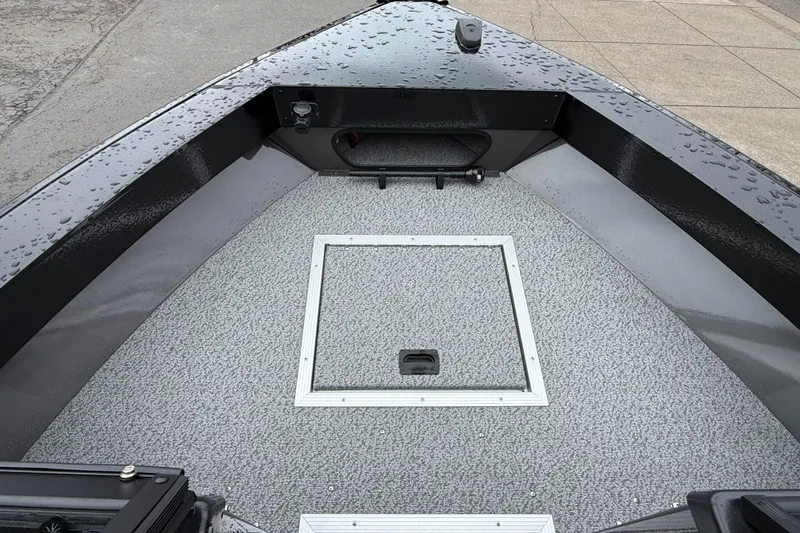 Slide: The Image of 2026 Smoker Craft Osprey 172 boat deck with storage hatch, wet from rain. - 19