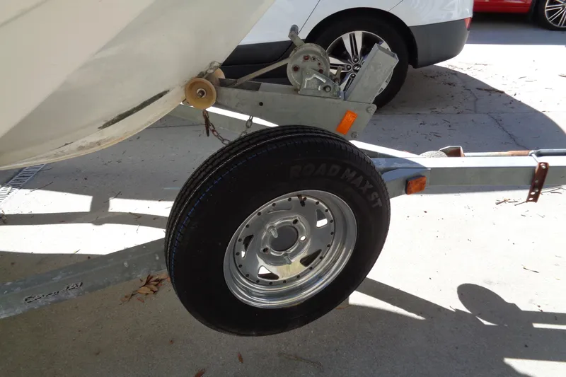 Slide: The Image of Trailer wheel of a 1970 Boston Whaler 17 Montauk boat in a driveway. - 11