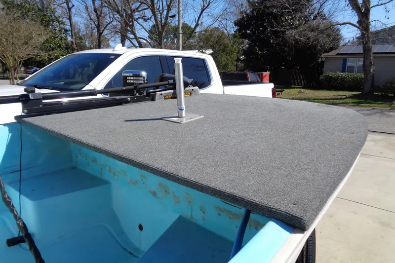 Slide: The Image of 1970 Boston Whaler 17 Montauk boat with carpeted deck, parked near a white truck. - 15