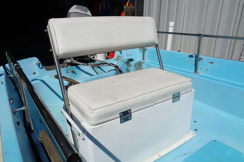 Slide: The Image of 1970 Boston Whaler 17 Montauk boat interior with white seating and blue deck. - 17