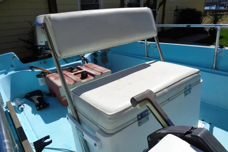 Slide: The Image of 1970 Boston Whaler 17 Montauk interior with white seating and blue deck. - 8