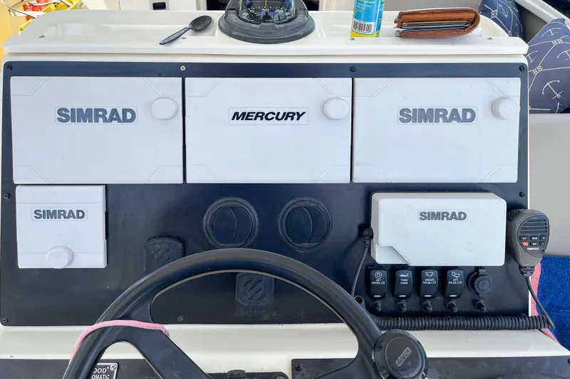 Slide: The Image of 1997 Pursuit 2870 Walkaround dashboard with Simrad and Mercury controls. - 4