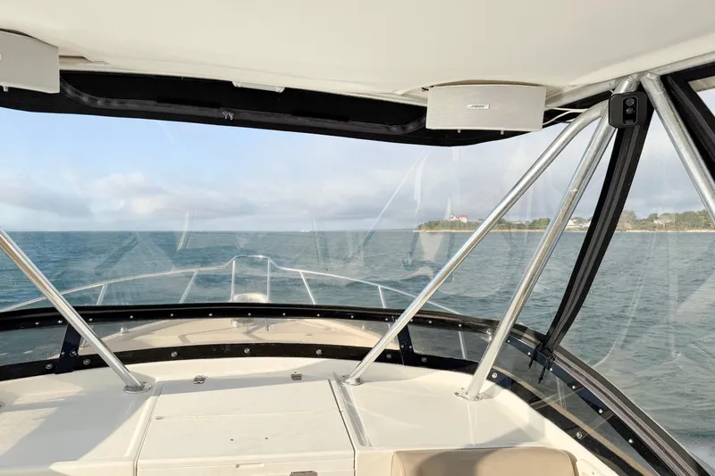 Slide: The Image of 1997 Pursuit 2870 Walkaround boat navigating open waters with distant shoreline view. - 5