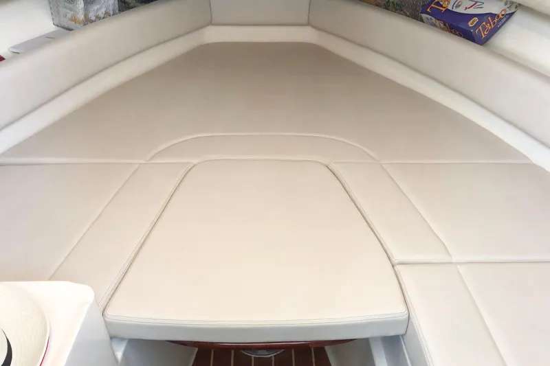 Slide: The Image of 1997 Pursuit 2870 Walkaround boat interior with beige cushioned seating area. - 7