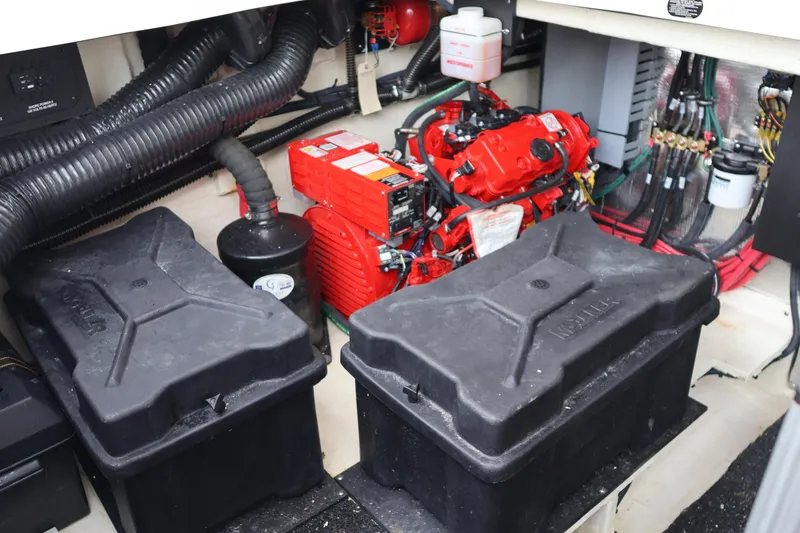 Slide: The Image of Engine compartment of 2022 Regal 36 XO boat with red engine and black battery boxes. - 11