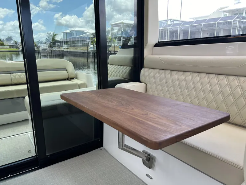 Slide: The Image of Interior of 2022 Regal 36 XO yacht with wooden table and cushioned seating. - 23