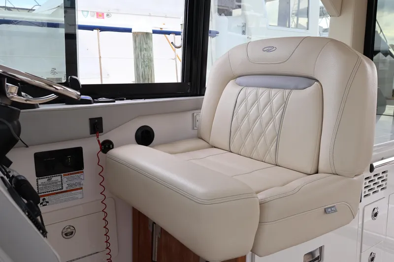 Slide: The Image of Luxurious helm seat in 2022 Regal 36 XO boat, featuring elegant beige upholstery. - 41