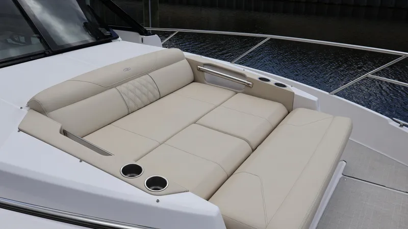Slide: The Image of Luxurious seating on the 2022 Regal 36 XO boat, featuring beige upholstery and cup holders. - 54
