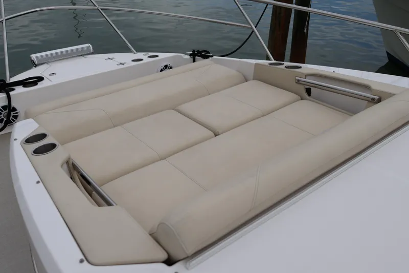 Slide: The Image of Luxurious seating area on 2022 Regal 36 XO boat, featuring beige upholstery and cup holders. - 56