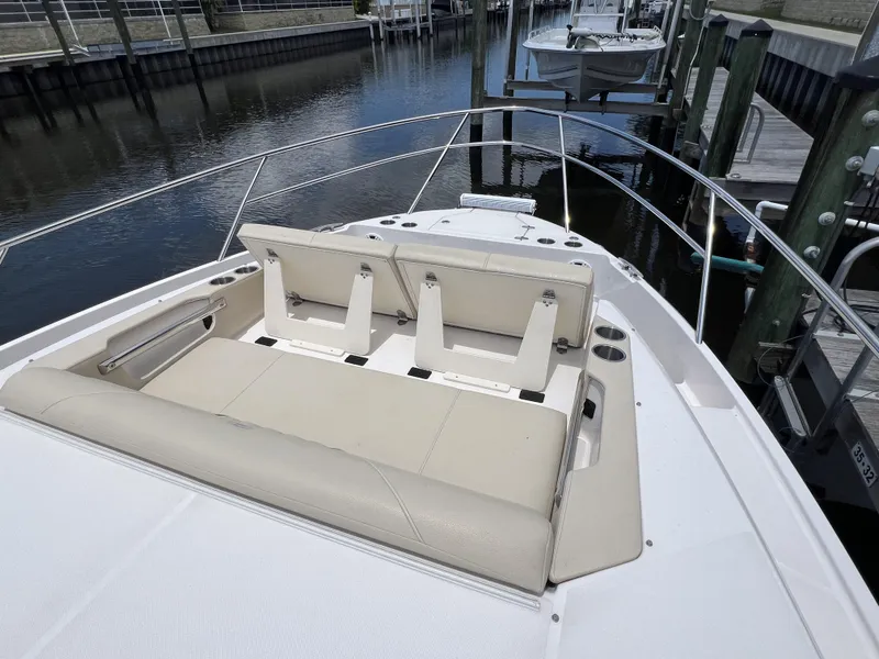 Slide: The Image of 2022 Regal 36 XO boat with beige seating at the bow, docked at a marina. - 57