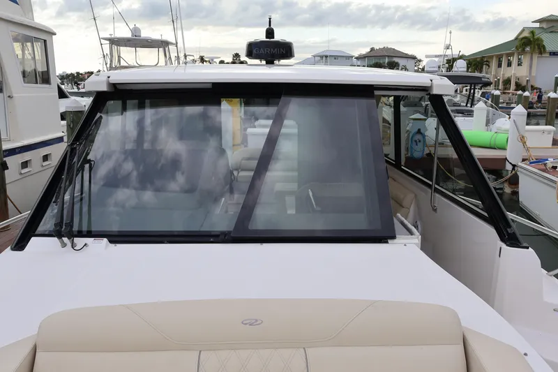 Slide: The Image of 2022 Regal 36 XO boat docked, featuring sleek design and modern windshield. - 62