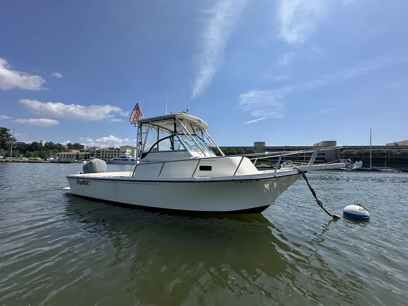 The Image of 2008 Parker 2310 Walkaround boat anchored on calm water under a clear blue sky. - 1
