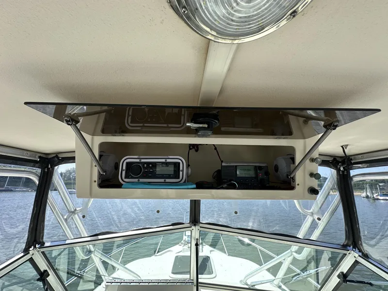 Slide: The Image of 2008 Parker 2310 Walkaround boat interior with radio equipment and open storage compartment. - 13