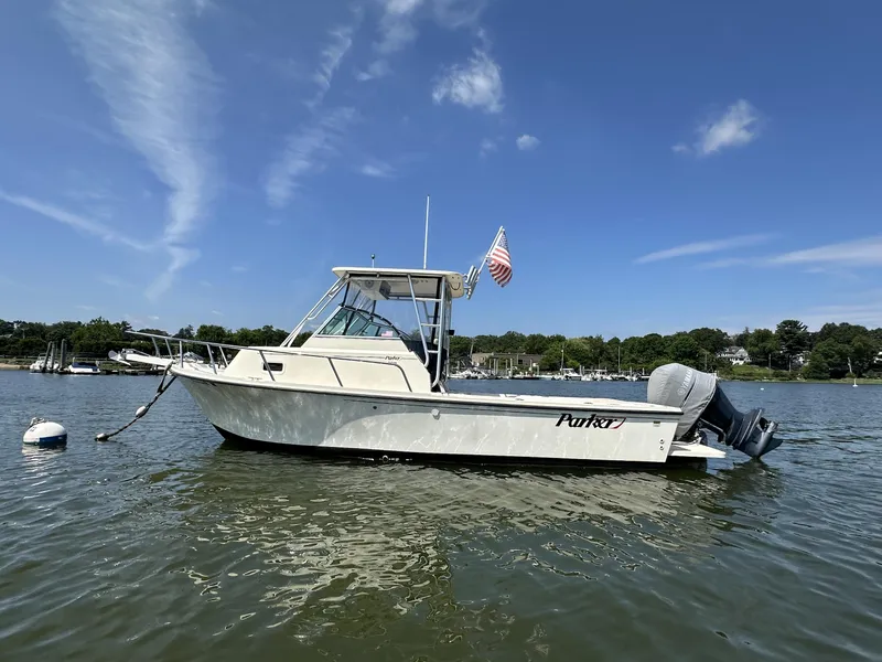 Slide: The Image of 2008 Parker 2310 Walkaround boat on calm water under clear blue sky. - 3