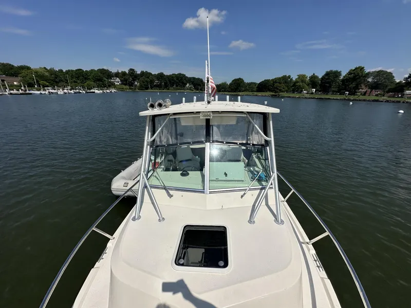 Slide: The Image of 2008 Parker 2310 Walkaround boat on a calm lake under a clear blue sky. - 9