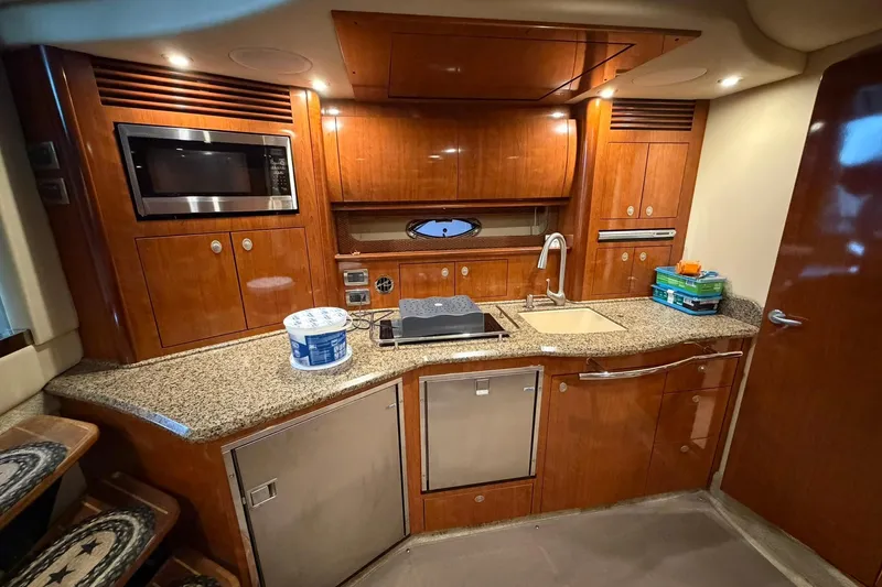 Slide: The Image of Luxurious 2005 Sea Ray 390 Sundancer yacht kitchen with wood cabinetry and modern appliances. - 13