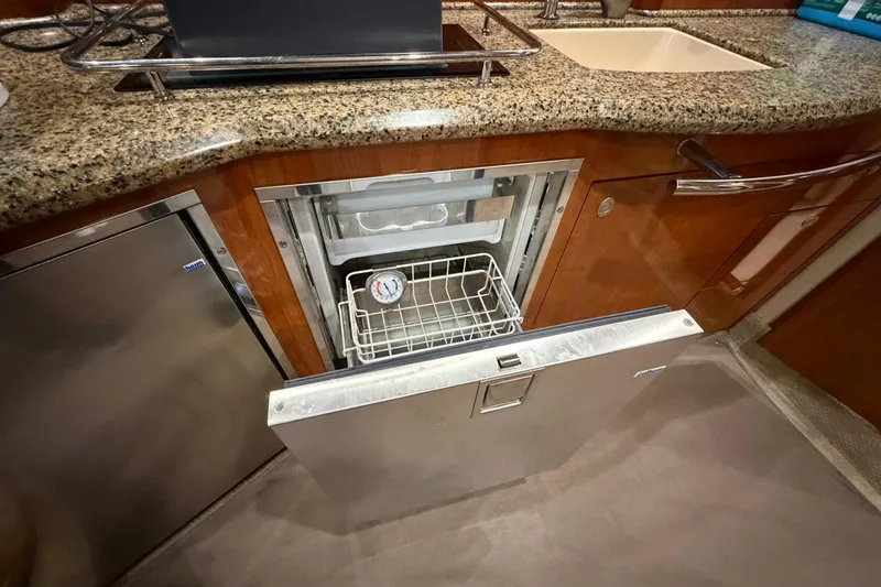 Slide: The Image of 2005 Sea Ray 390 Sundancer yacht kitchen with open stainless steel fridge and granite countertop. - 14
