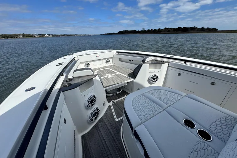 Slide: The Image of 2023 Crevalle 33 CSF boat interior with seating and table on calm water. - 10