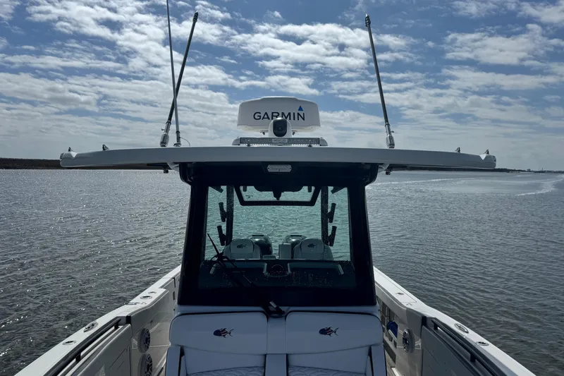 Slide: The Image of 2023 Crevalle 33 CSF boat on water, featuring Garmin equipment under a cloudy sky. - 13