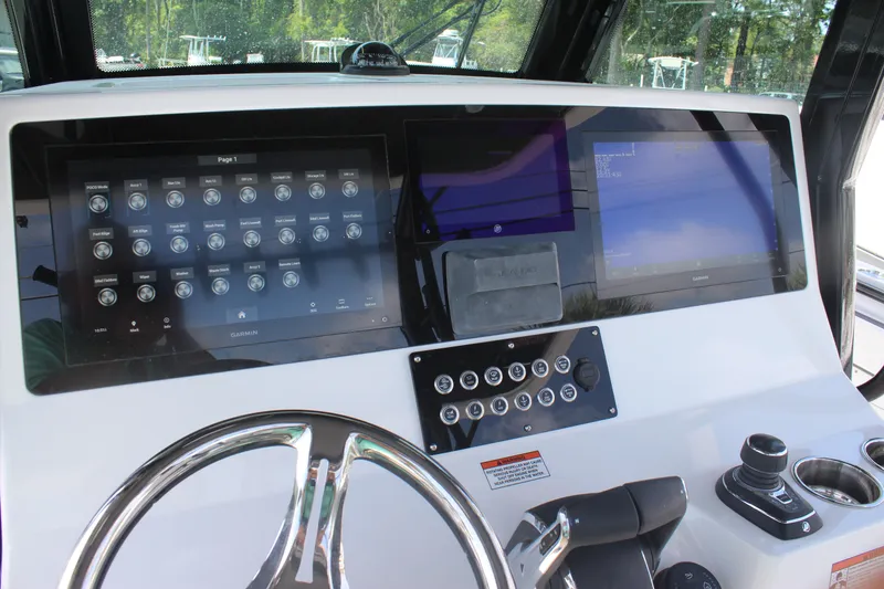 Slide: The Image of 2023 Crevalle 33 CSF boat dashboard with dual Garmin displays and steering wheel. - 15