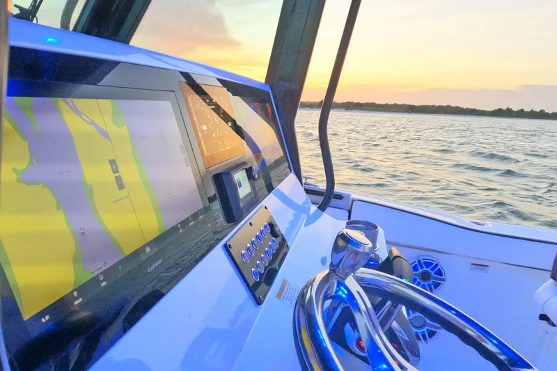 Slide: The Image of 2023 Crevalle 33 CSF boat dashboard with navigation screens at sunset. - 20