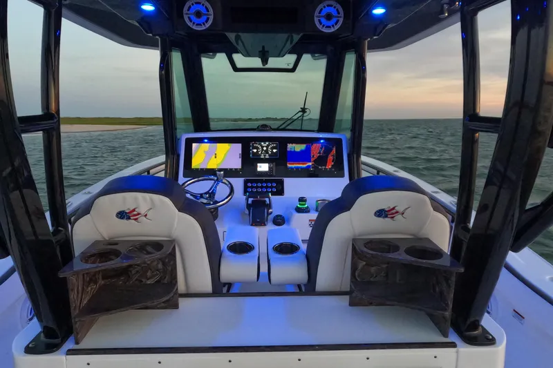 Slide: The Image of 2023 Crevalle 33 CSF boat cockpit with illuminated dashboard and dual seating. - 23