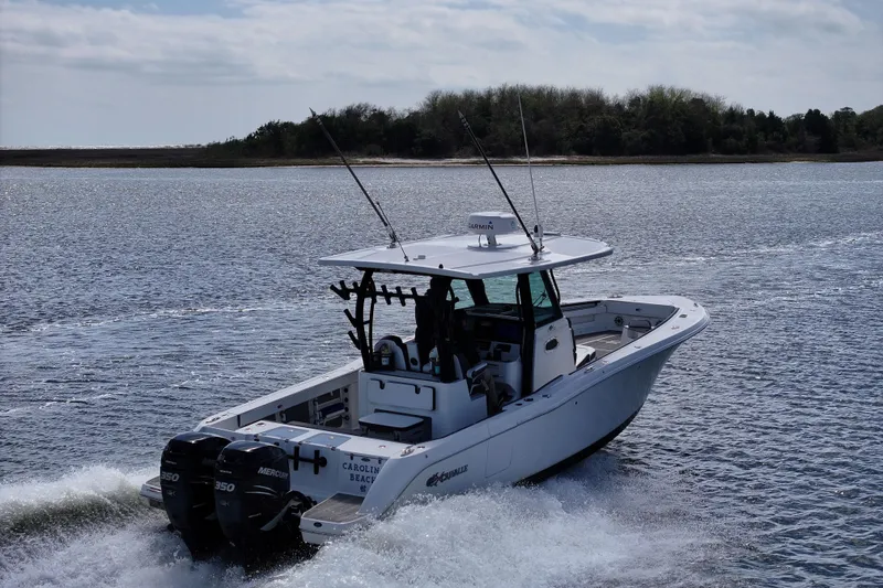 Slide: The Image of 2023 Crevalle 33 CSF boat cruising on open water with twin Mercury engines. - 3