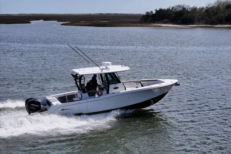 Slide: The Image of 2023 Crevalle 33 CSF boat cruising on open water with scenic background. - 4
