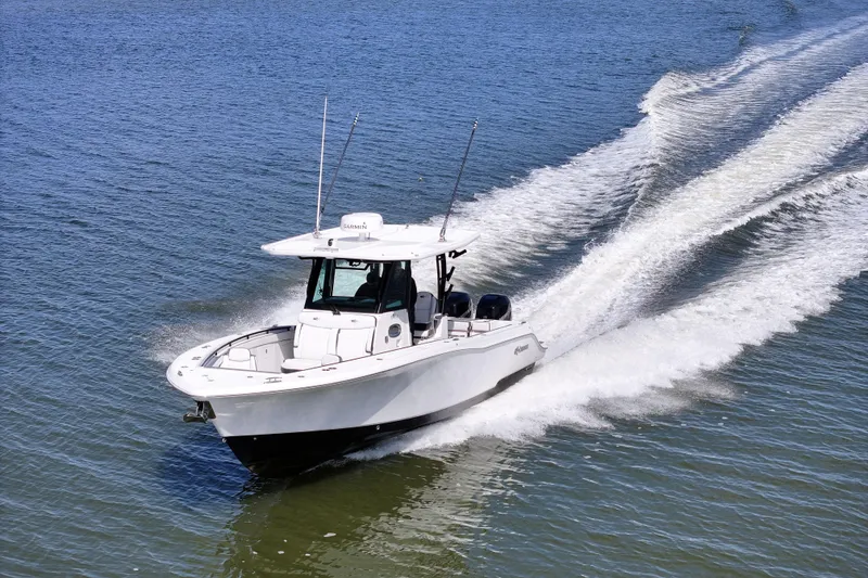 Slide: The Image of 2023 Crevalle 33 CSF boat cruising on open water, creating a wake. - 5