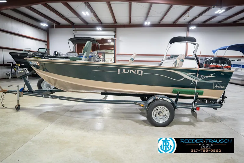 Slide: The Image of 1999 Lund 1650 Explorer SS boat on trailer in indoor showroom. - 10