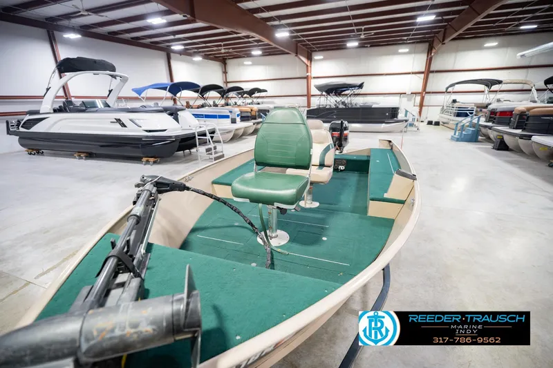 Slide: The Image of 1999 Lund 1650 Explorer SS boat in showroom with green interior and motor. - 11