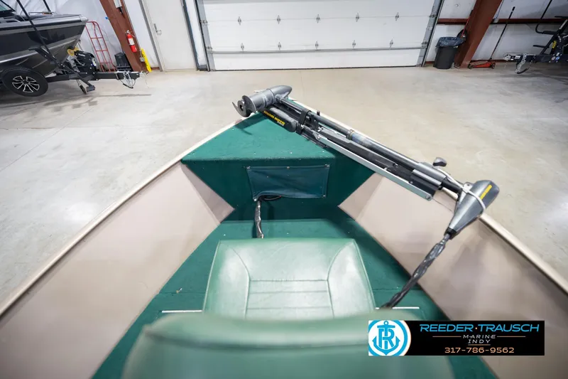 Slide: The Image of 1999 Lund 1650 Explorer SS boat interior with green seating and trolling motor. - 17