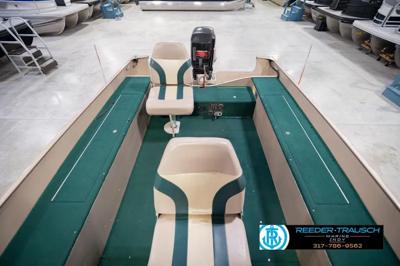 Slide: The Image of 1999 Lund 1650 Explorer SS boat interior with green seating and Mercury outboard motor. - 19