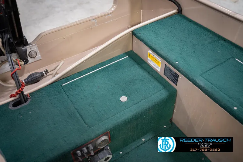 Slide: The Image of Interior of a 1999 Lund 1650 Explorer SS boat with green carpet and control panel. - 21