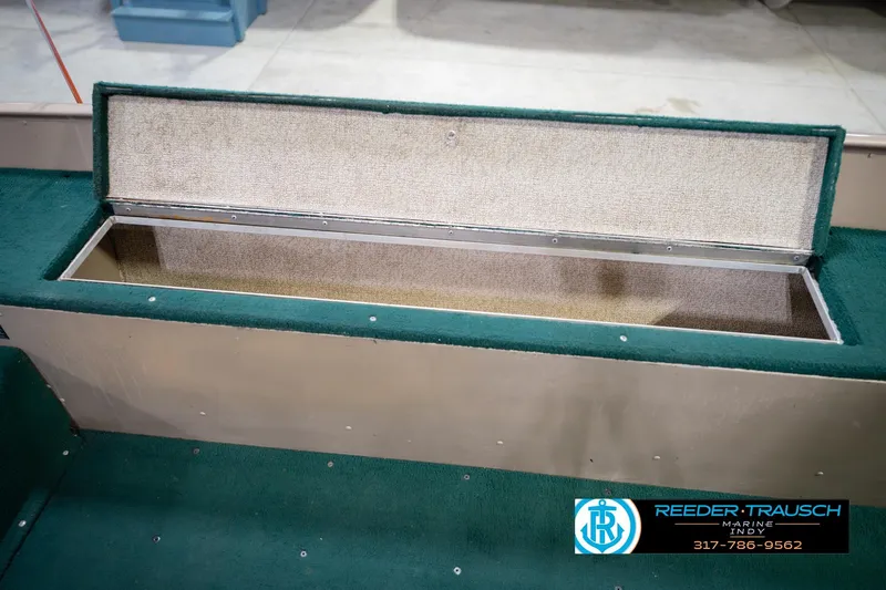 Slide: The Image of Open storage compartment in 1999 Lund 1650 Explorer SS boat with green carpet interior. - 24