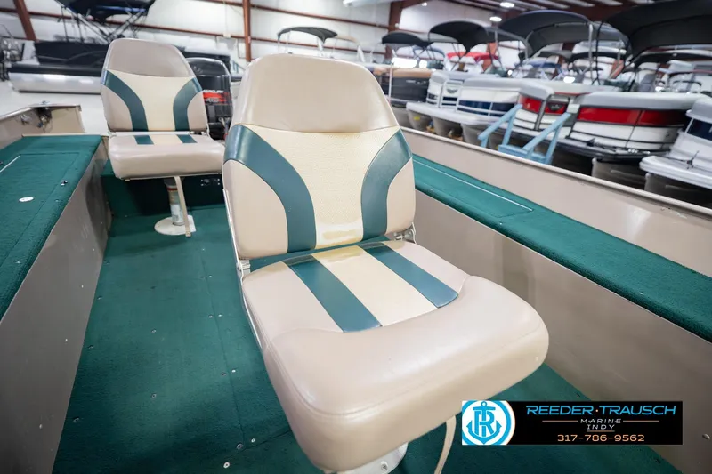 Slide: The Image of Interior of a 1999 Lund 1650 Explorer SS boat with green and beige seating. - 30