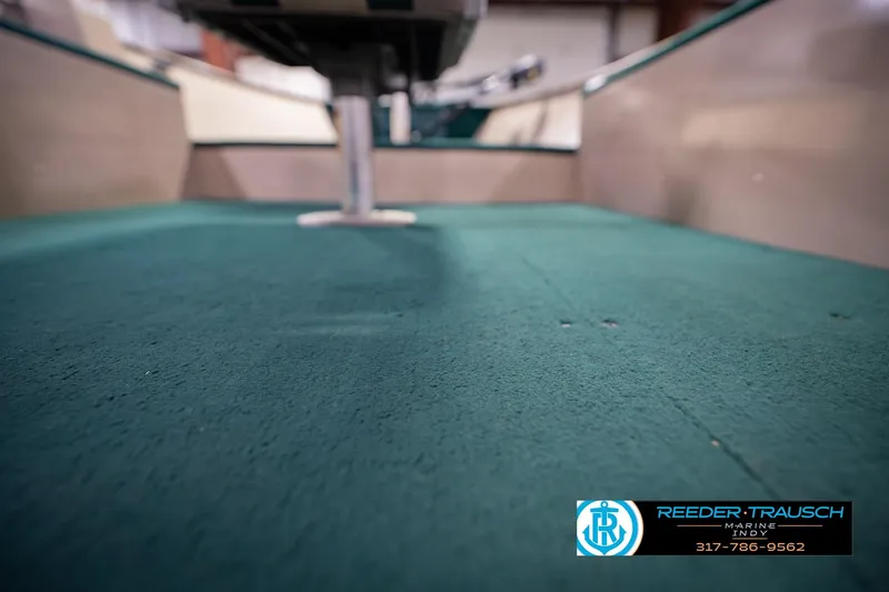 Slide: The Image of 1999 Lund 1650 Explorer SS boat interior with green carpet and seating. - 32