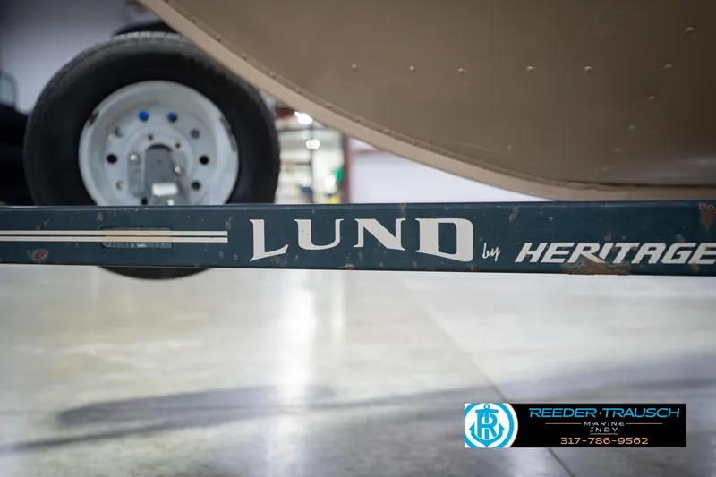 Slide: The Image of Trailer of 1999 Lund 1650 Explorer SS boat by Heritage, in a showroom. - 44