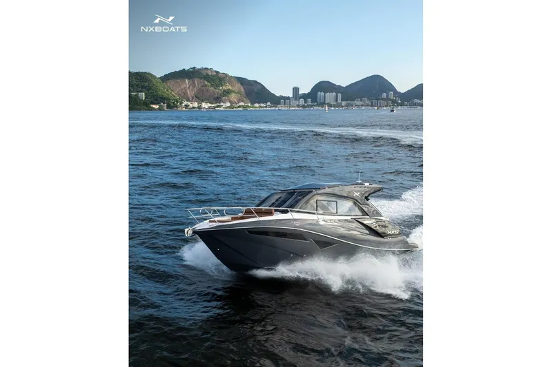 The Image of 2026 NX Boats NX370 cruising on water with scenic coastal backdrop. - 0