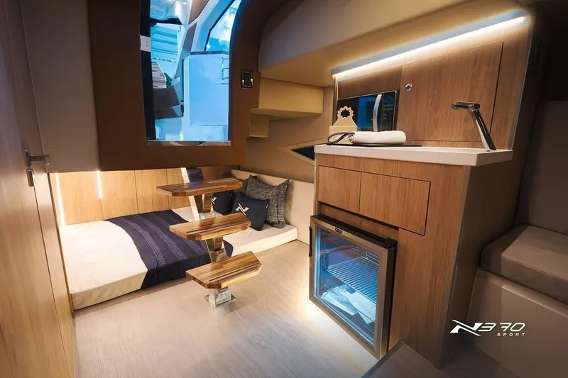 Slide: The Image of Interior of 2026 NX Boats NX370, featuring modern kitchenette and cozy sleeping area. - 10