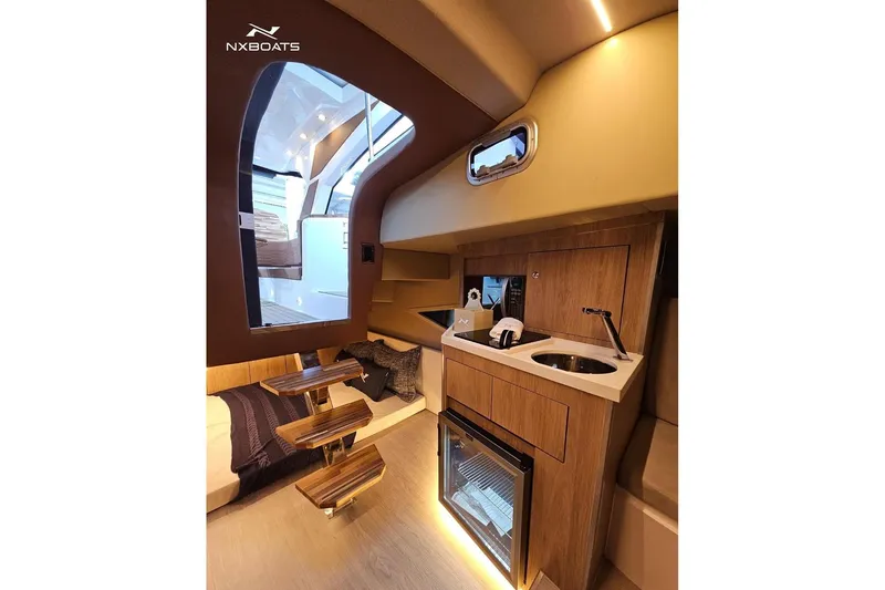 Slide: The Image of Interior of 2026 NX Boats NX370, featuring modern kitchenette and stylish wooden accents. - 11
