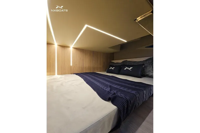 Slide: The Image of Luxurious interior of 2026 NX Boats NX370 with modern lighting and elegant bedding. - 13