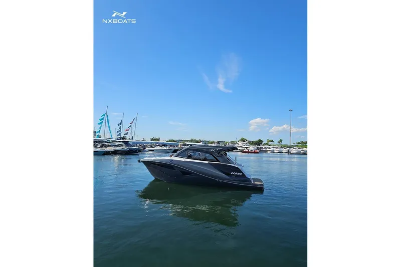 Slide: The Image of 2026 NX Boats NX370 yacht docked in a marina under a clear blue sky. - 3