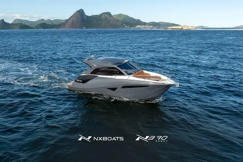 Slide: The Image of 2026 NX Boats NX370 cruising on open water with scenic mountain backdrop. - 4