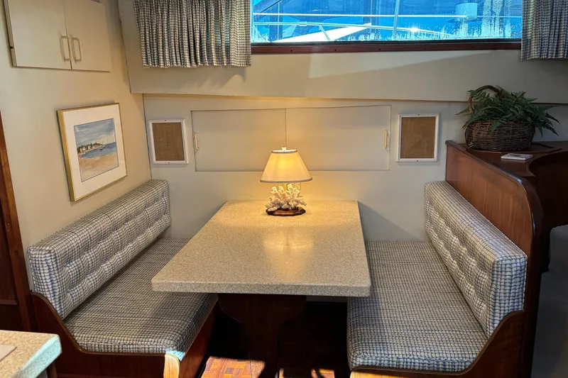 Slide: The Image of Cozy dining area in a 1979 Hatteras 53 Motor Yacht with a lamp and artwork. - 17