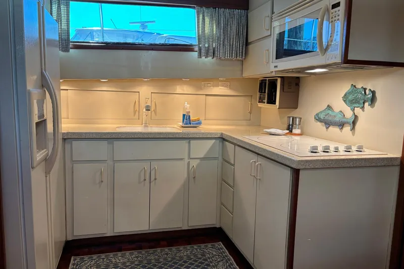 Slide: The Image of 1979 Hatteras 53 Motor Yacht kitchen with white cabinets and modern appliances. - 18