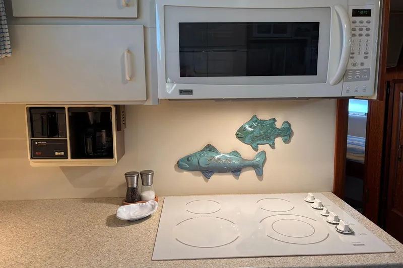 Slide: The Image of Kitchen area of a 1979 Hatteras 53 Motor Yacht with stove, microwave, and fish decor. - 20