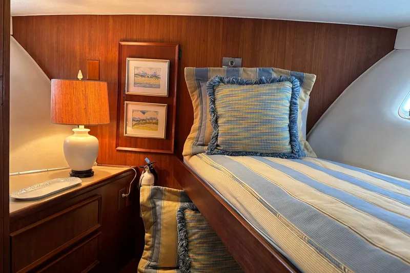 Slide: The Image of Cozy cabin interior of 1979 Hatteras 53 Motor Yacht with striped bedding and warm lighting. - 23