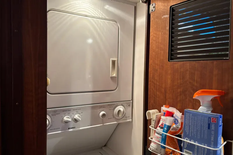 Slide: The Image of Laundry area inside a 1979 Hatteras 53 Motor Yacht with washer and cleaning supplies. - 24