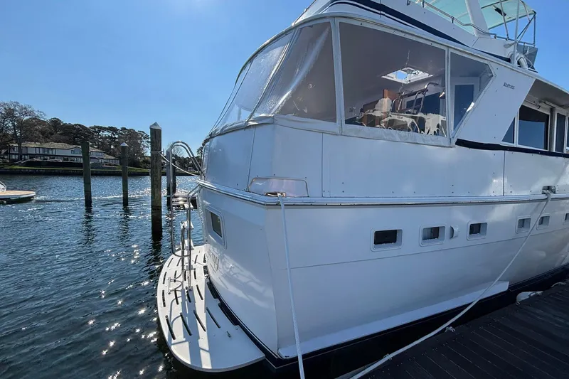Slide: The Image of 1979 Hatteras 53 Motor Yacht docked in a sunny marina setting. - 3